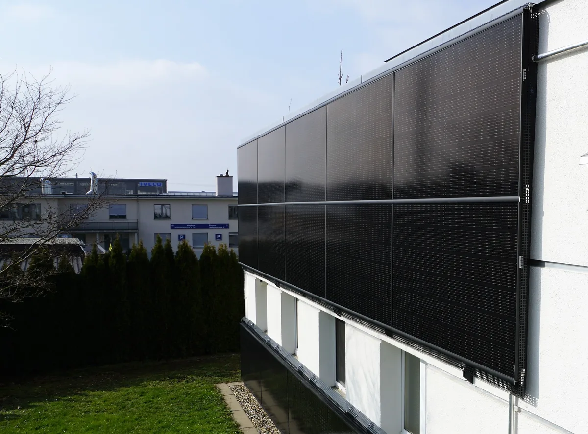 Man sieht Solarpanels an der Fassade eines Hauses.